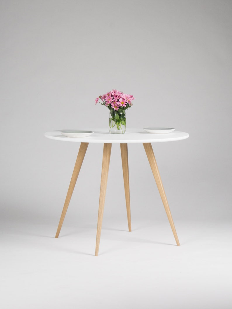Round dining table with four solid oak legs and MDF finish