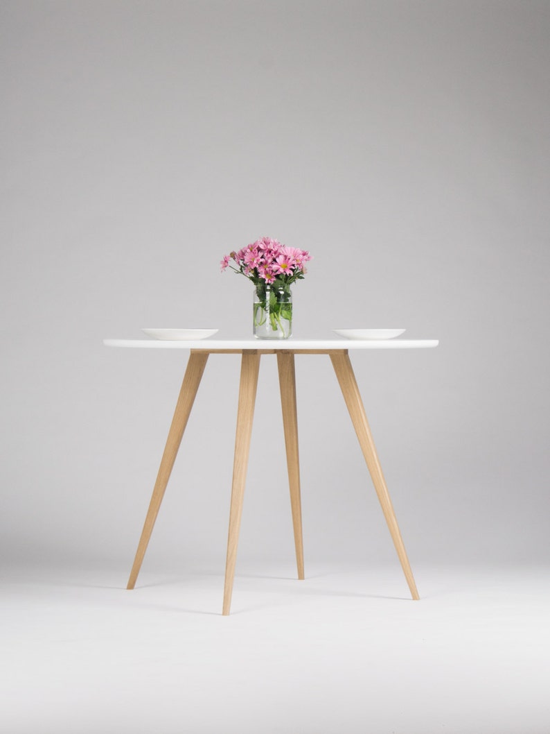 Round dining table with four solid oak legs and MDF finish
