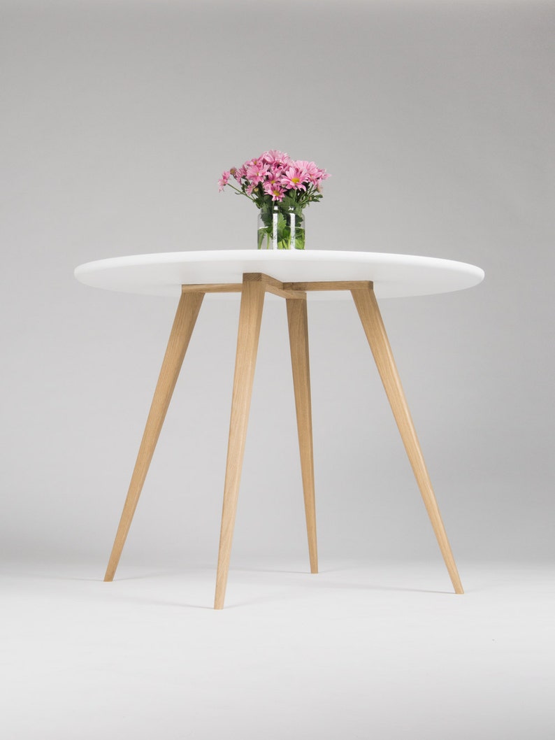 Round dining table with four solid oak legs and MDF finish