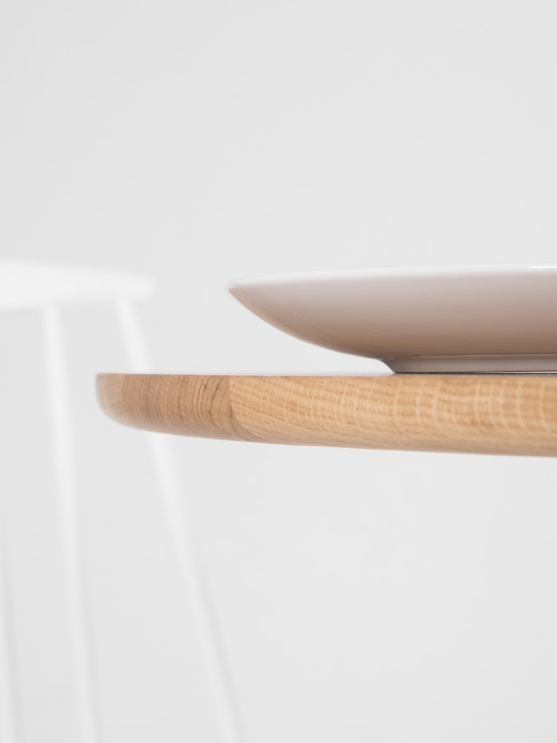 Round dining table with four solid oak legs and natural wood finish