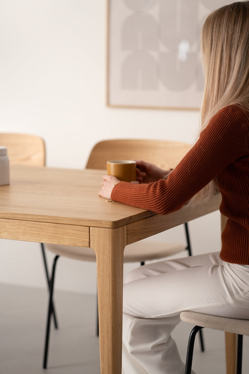 Solid oak dining table with natural finish and minimalist lines, ideal for gatherings, seats 6 to 8 people