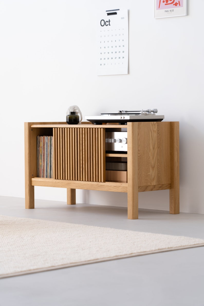 Compact solid oak wood console with slatted sliding doors and vinyl storage