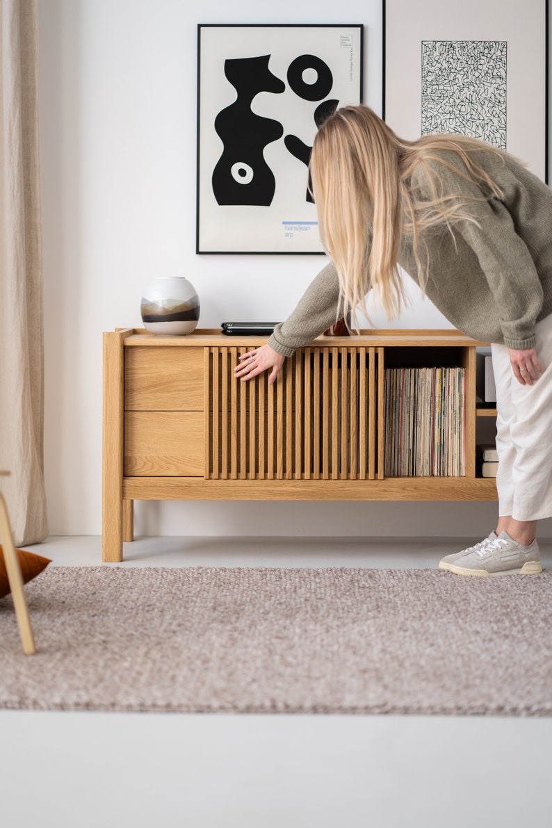 Wide oak TV console with slatted doors, drawers, and cable management