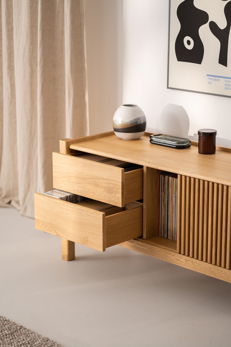 Wide oak TV console with slatted doors, drawers, and cable management