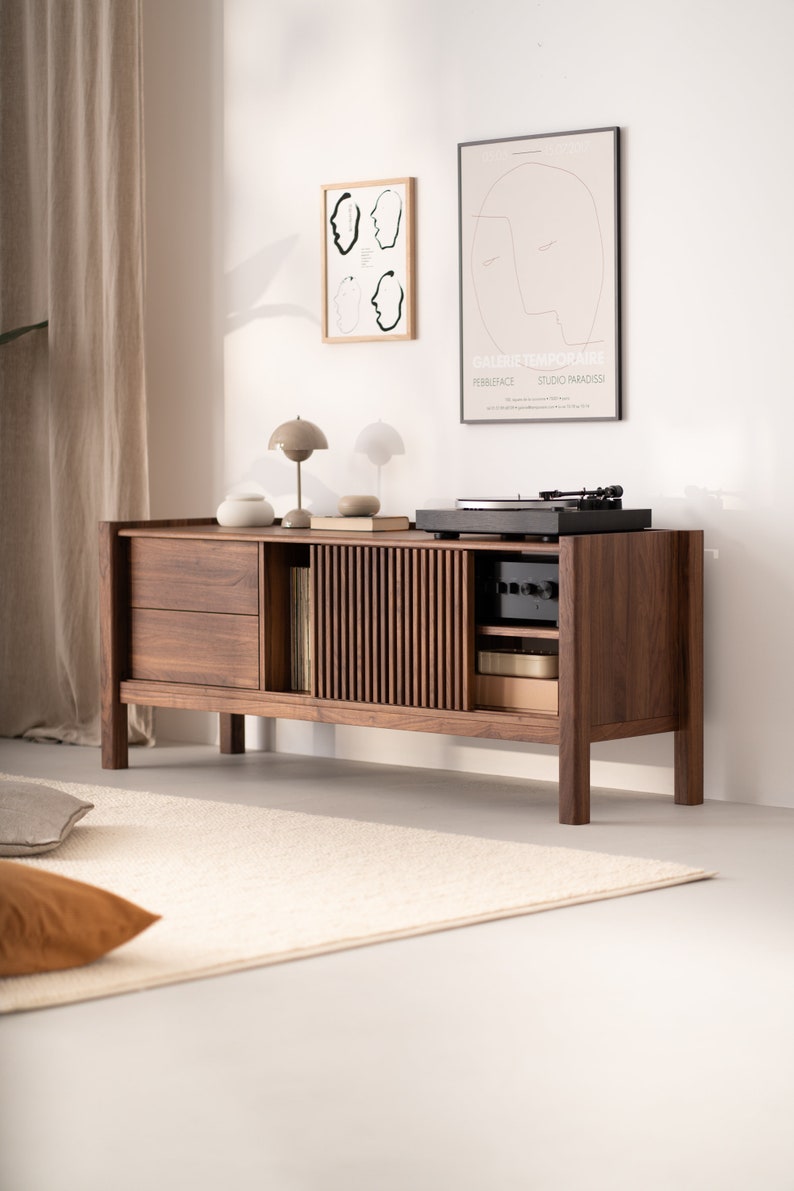 Wide walnut TV console with slatted doors, drawers, and cable management