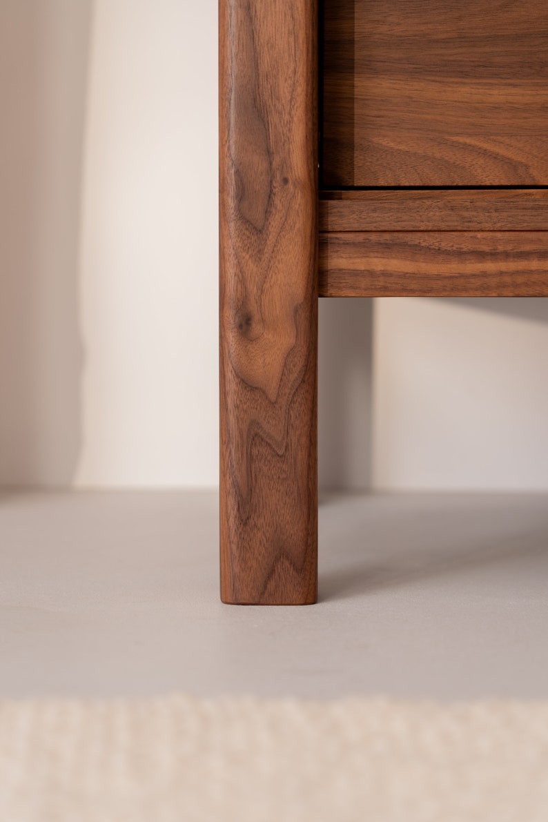 Wide walnut TV console with slatted doors, drawers, and cable management