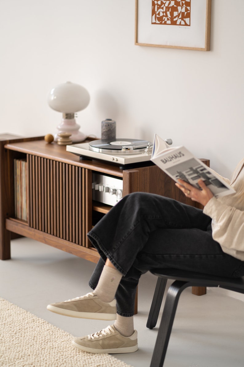 Wide walnut TV console with slatted doors, drawers, and cable management