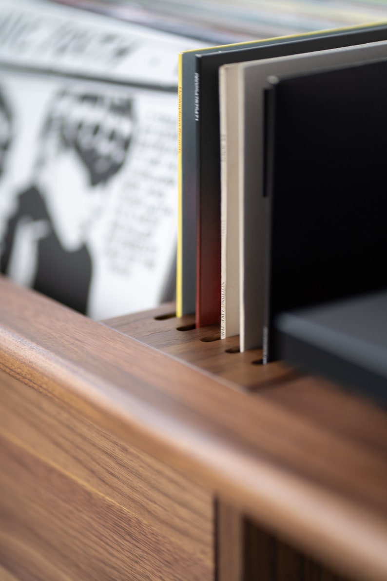Low-profile media console in walnut with sliding front panel