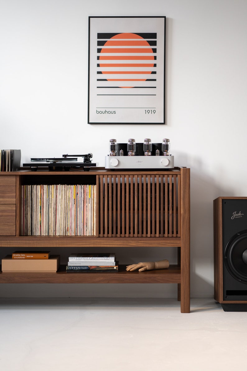 Low-profile media console in walnut with sliding front panel