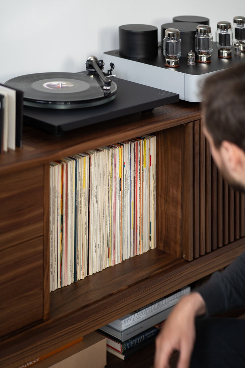 Low-profile media console in walnut with sliding front panel