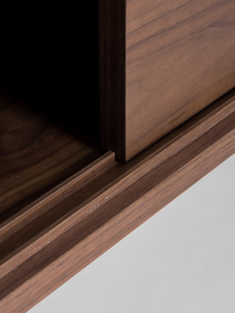 KUUB TV console with two side-sliding doors, walnut veneer, customizable wood fronts, cable holes, and hardwax oil finish