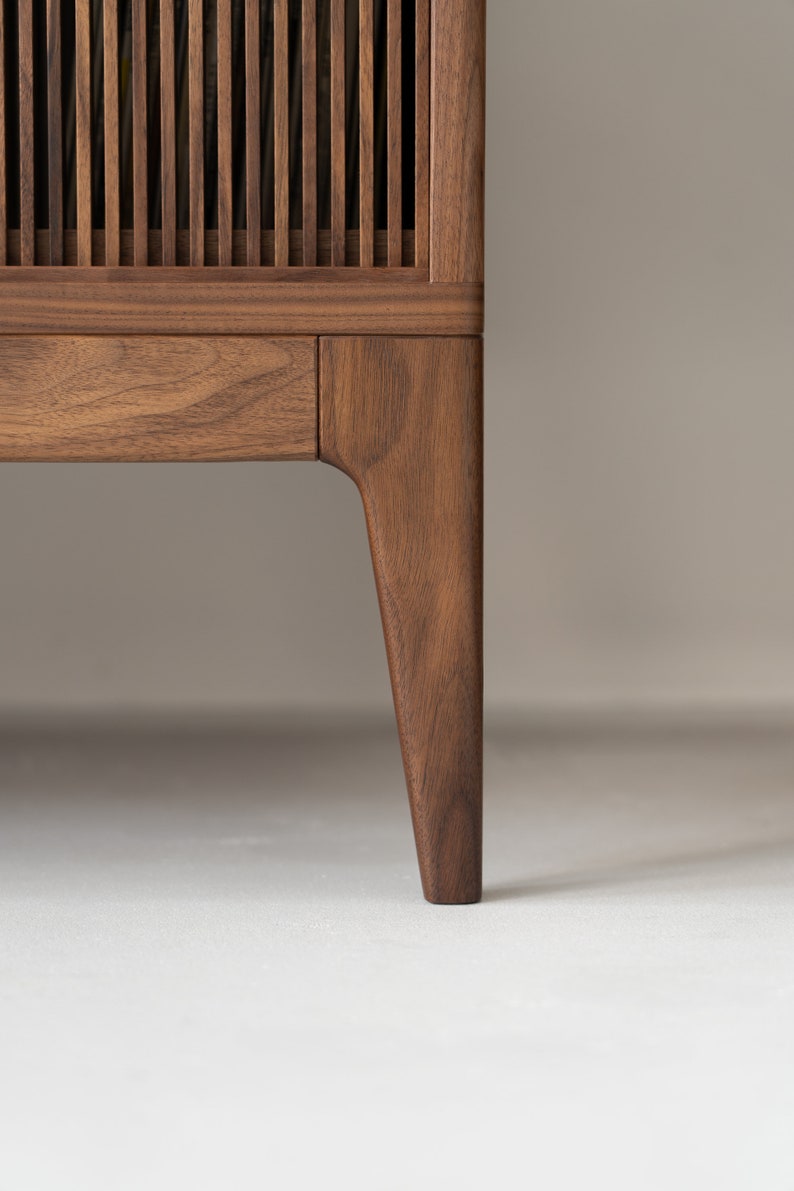 Wide walnut media console with openwork front and customizable compartments 